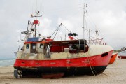 Fishing boat on the sand coast.